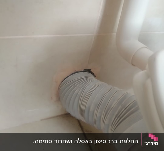 צינור גמיש מחובר לקיר בחדר אמבטיה